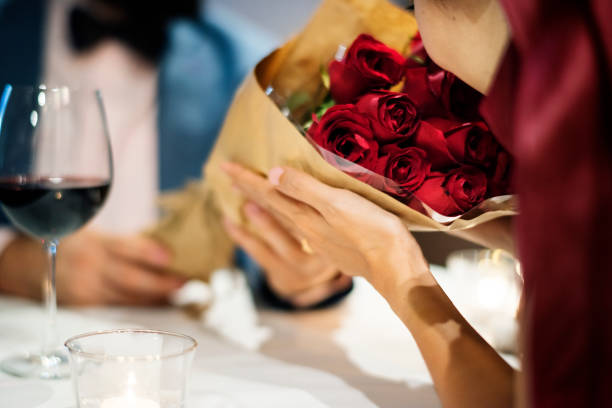 Person handing bouquet of flowers to another person